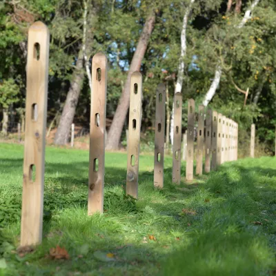 Vierkantpfosten aus Holz bei der Installation auf einem Feld