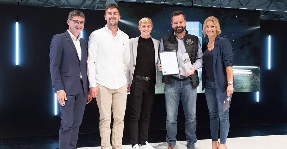 Eine Gruppe von Menschen, die mit einer Trophäe nebeneinander stehen